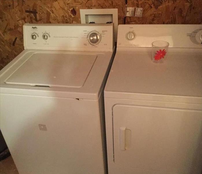 white washer and dryer in closet with debris removed