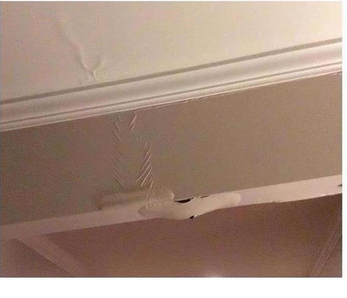 ceiling of home with white paint bubbling up from water damage