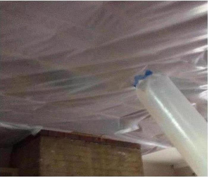 plastic tarping on the timbers of attic in a home