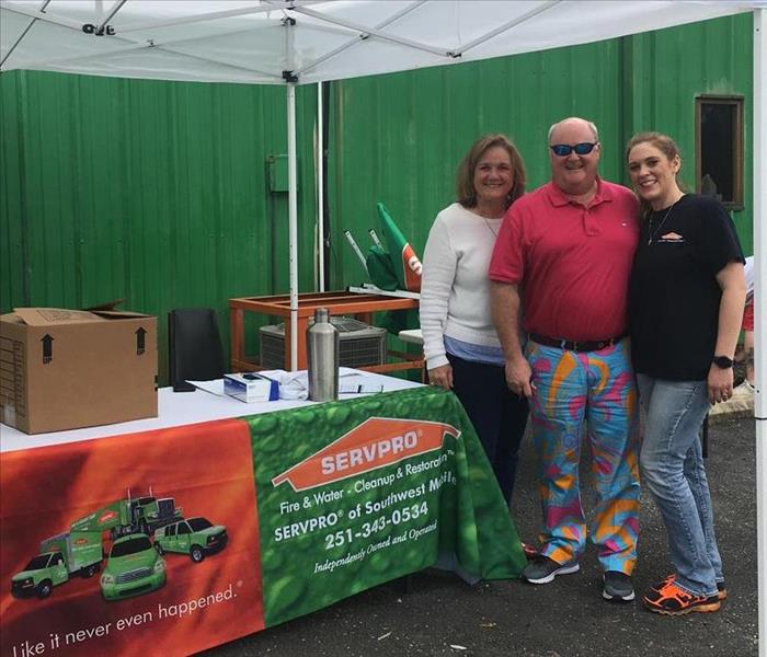 table with SERVPRO cloth and 3 people